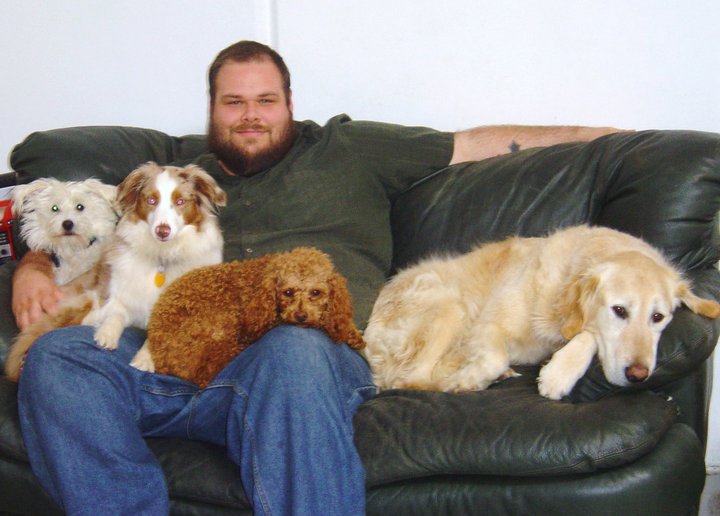 Erik seated with dogs while working at Uppity Pup